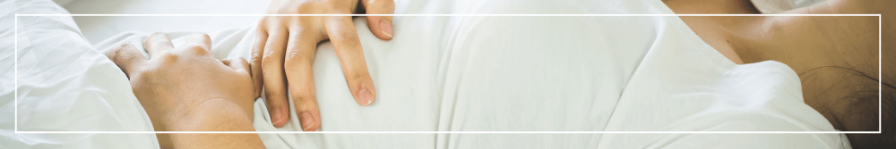 woman lying down holding tummy
