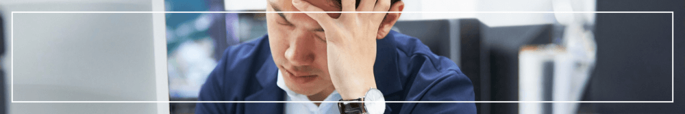 stressed man at work with head in his hands